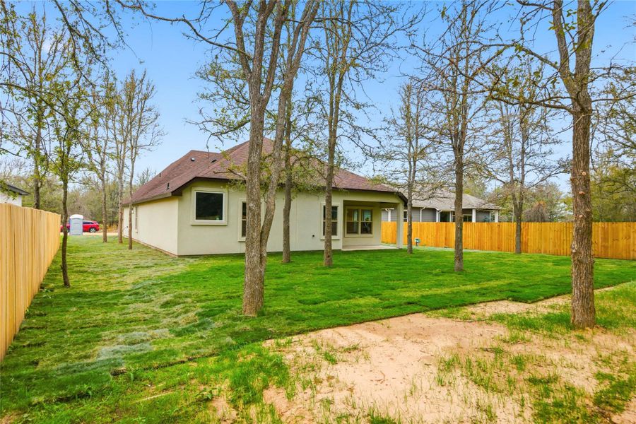 Back of property with a fenced backyard, a patio area, a shingled roof, and stucco siding