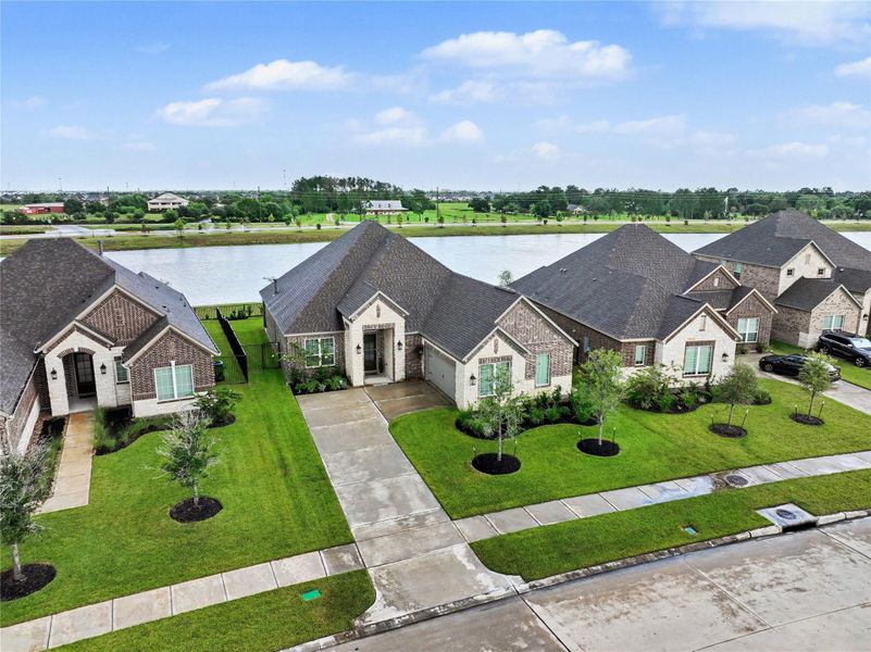 This photo showcases a modern, single-story brick home with a well-maintained lawn, situated in a scenic neighborhood with a waterfront view. The property features a driveway and neatly landscaped front yard, providing an inviting curb appeal. This photo showcases a modern, single-story brick home with a well-maintained lawn, situated in a scenic neighborhood with a waterfront view. The property features a driveway and neatly landscaped front yard, providing an inviting curb appeal.