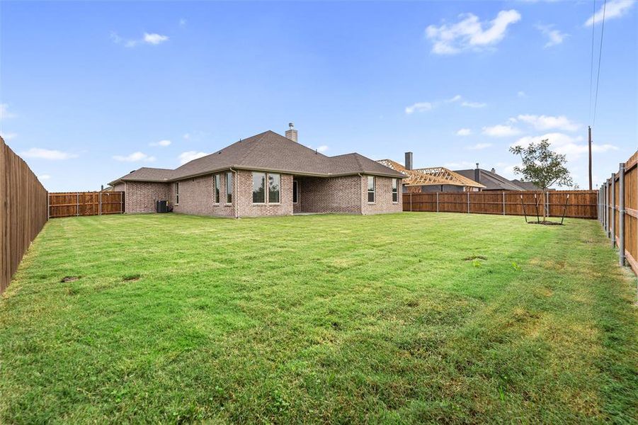 Back of property featuring a fenced backyard, a chimney, brick siding, a patio area, and roof with shingles Back of property featuring a fenced backyard, a chimney, brick siding, a patio area, and roof with shingles