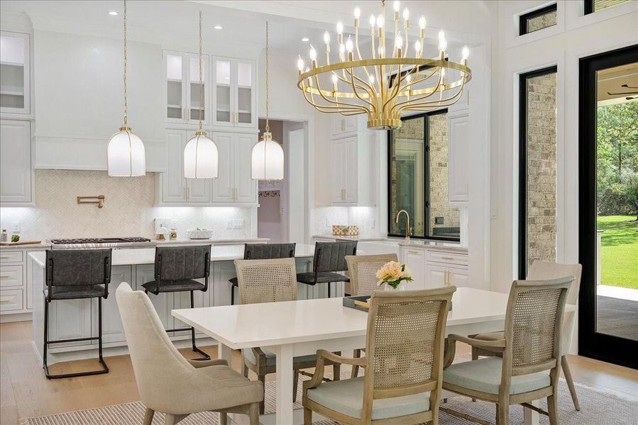 Oversized pendant lighting and layered illumination give the kitchen warmth, drama, and the flexibility to move effortlessly from family life to evening entertaining.