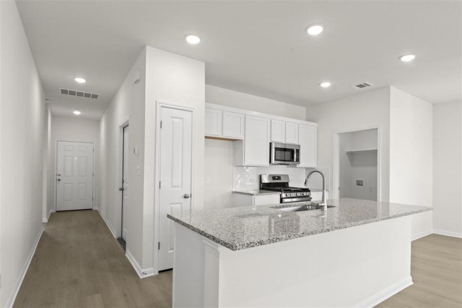 Kitchen featuring white cabinetry, visible vents, appliances with stainless steel finishes, and a sink