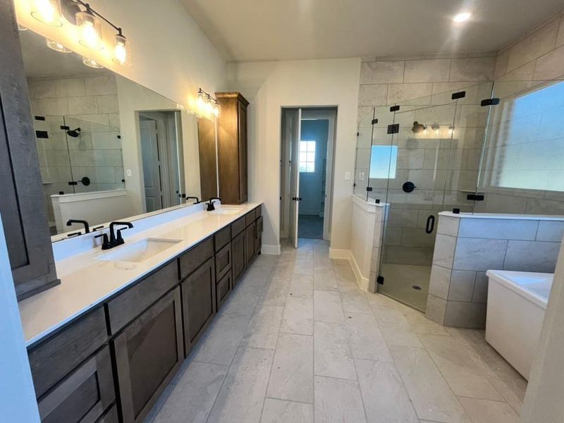 Full bath featuring double vanity, a shower stall, and a soaking tub