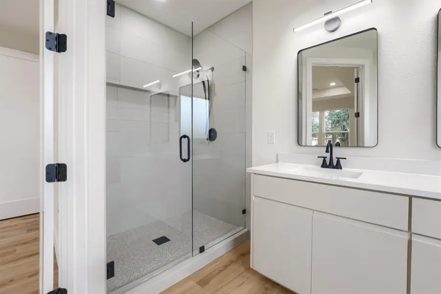 Modern bathroom with a spacious glass-enclosed shower, and a white tile surround