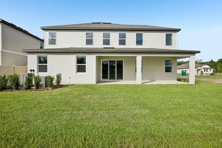 Back of the Amelia home features a large covered back lanai and a large sliding glass door