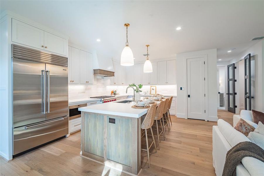 Kitchen featuring appliances with stainless steel finishes, light wood-type flooring, and white cabinets