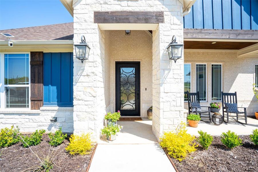 Property entrance featuring stone siding, board and batten siding, a porch, and roof with shingles Property entrance featuring stone siding, board and batten siding, a porch, and roof with shingles
