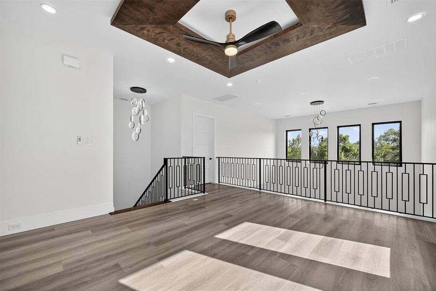 Empty room featuring recessed lighting, a tray ceiling, wood finished floors, and a ceiling fan