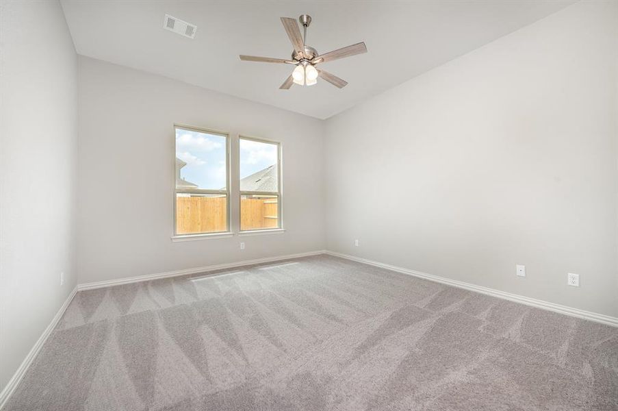 Carpeted empty room with ceiling fan