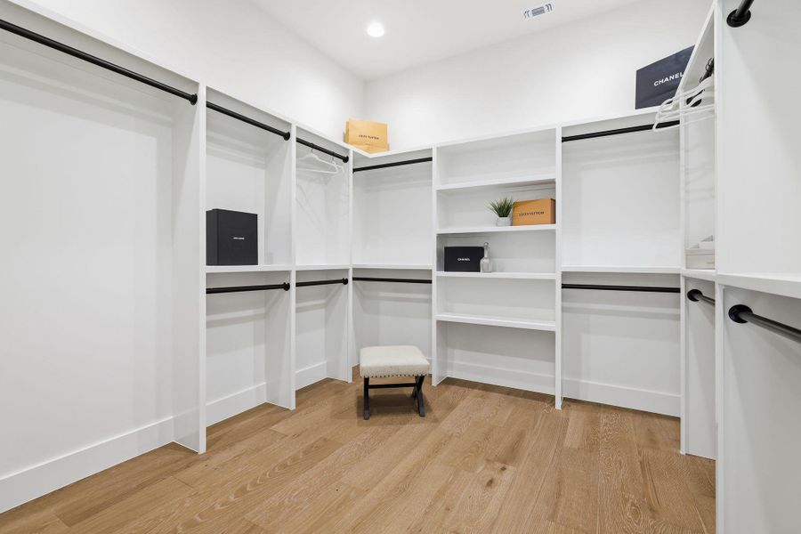 Walk in closet with light wood-style flooring