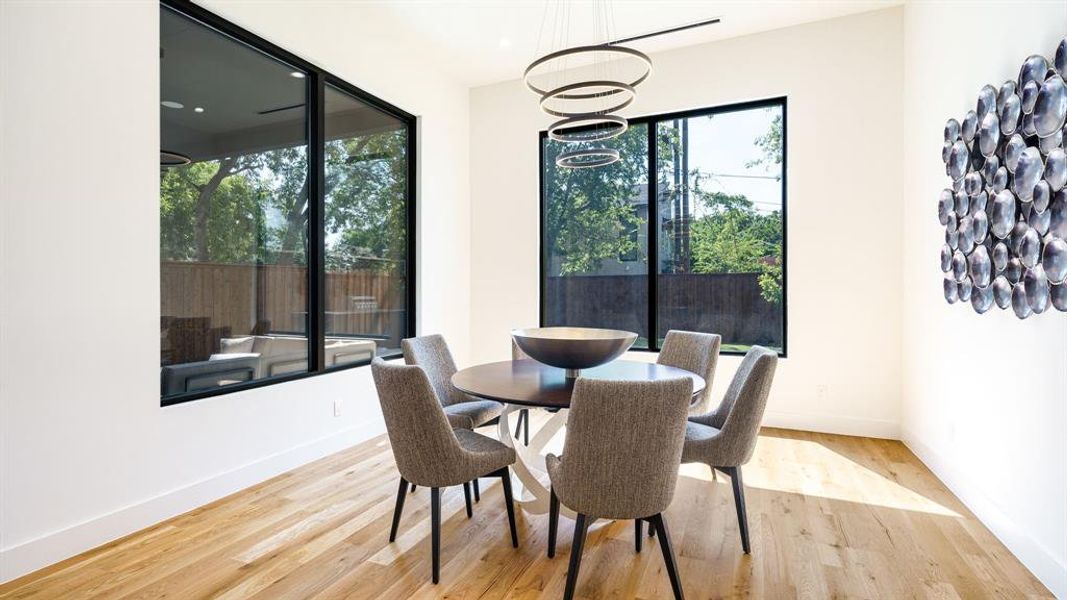 Dining space with light wood-type flooring and an inviting chandelier