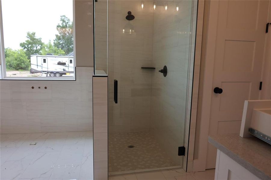 Bathroom with tile patterned floors and a shower with door