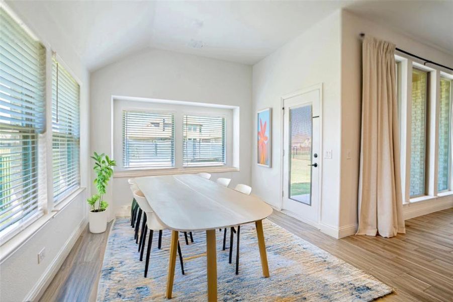 Dining room with light wood-style flooring and vaulted ceiling Dining room with light wood-style flooring and vaulted ceiling