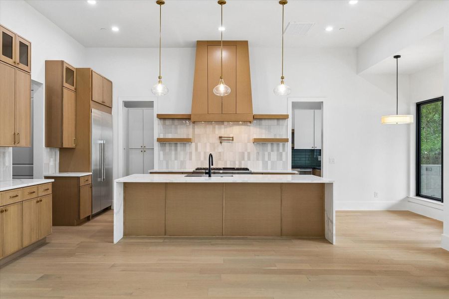 The quartz counters have a waterfall edge encompassing the sides of the island. The deep knee space furnishes a bar seating area to visit with the chef.