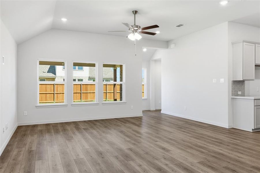 Unfurnished living room featuring ceiling fan, lofted ceiling, recessed lighting, and light wood-style floors
