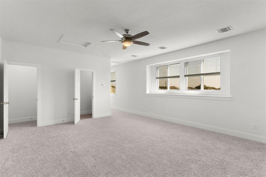 Unfurnished bedroom with attic access, light carpet, and a ceiling fan