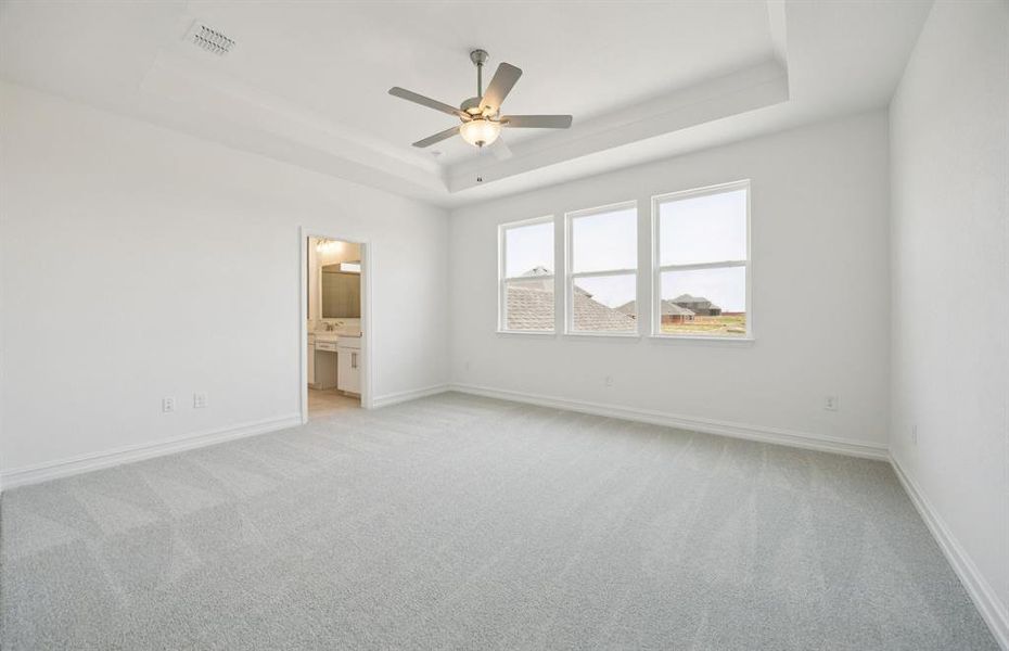 Spacious owner's suite highlighted by large windows and an exquisite tray ceiling  *Real home pictured