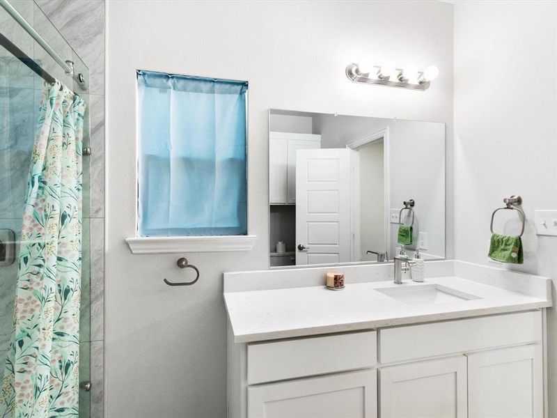 Bathroom featuring a white vanity with an integrated sink, polished chrome faucet, and a large mirror