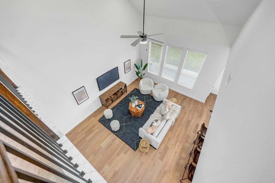 Living room with high vaulted ceiling, ceiling fan, and wood finished floors