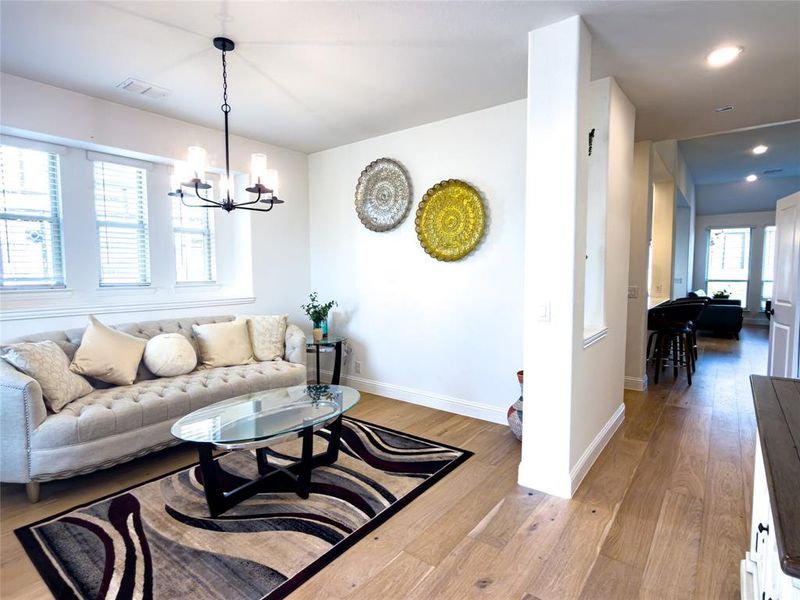 Living area featuring light wood-style floors and a chandelier