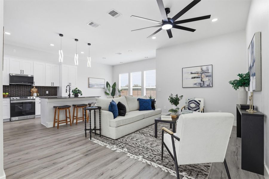 Open-concept living space featuring wood-finish flooring, recessed lighting, and a contemporary ceiling fan