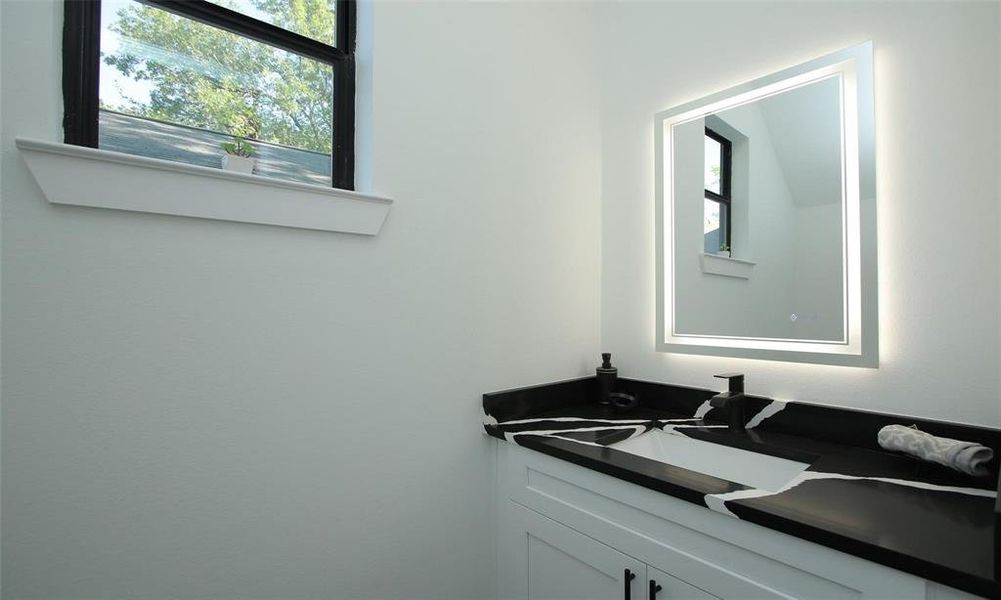 Guest.half bath located along the hallway leading to the primary suite off the kitchen.