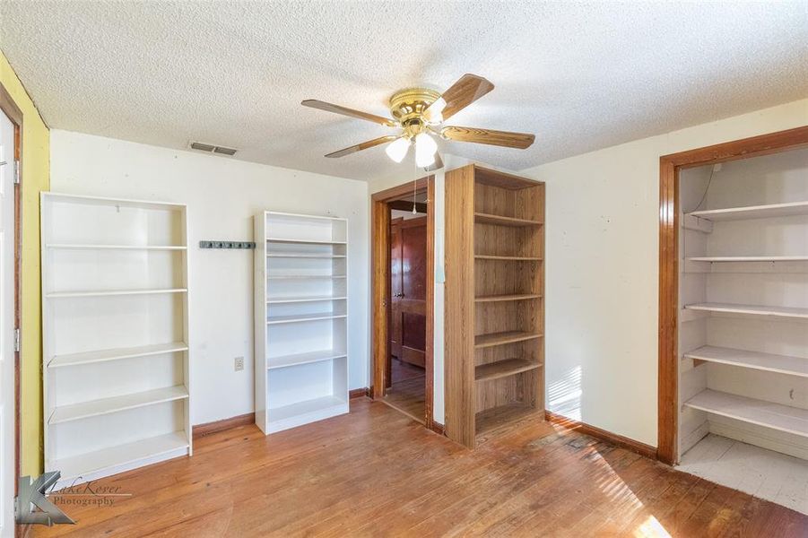 Unfurnished bedroom featuring a closet, a textured ceiling, light wood-style flooring, and ceiling fan Unfurnished bedroom featuring a closet, a textured ceiling, light wood-style flooring, and ceiling fan