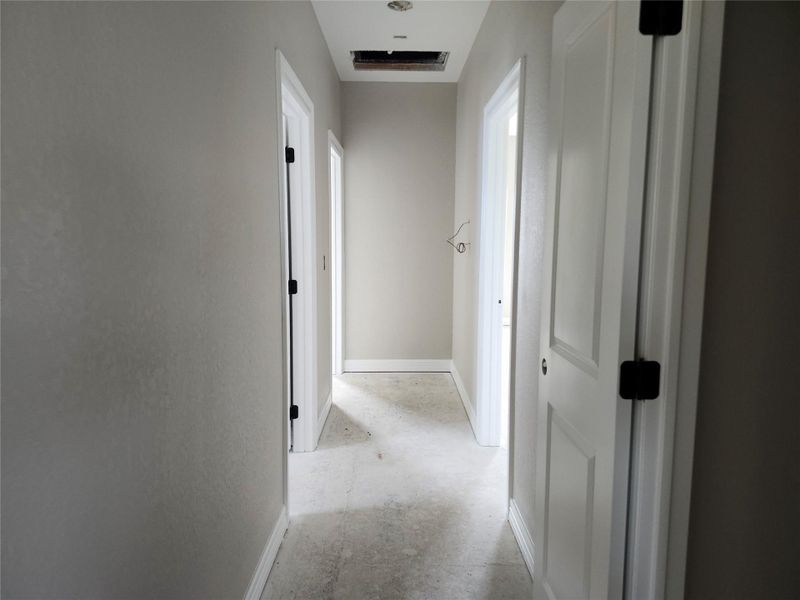 This photo features a hallway with light gray walls and white trim.