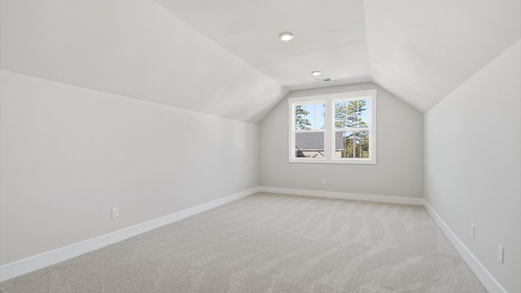 Highly functional bonus room featuring cozy carpet and open views of the home’s living areas