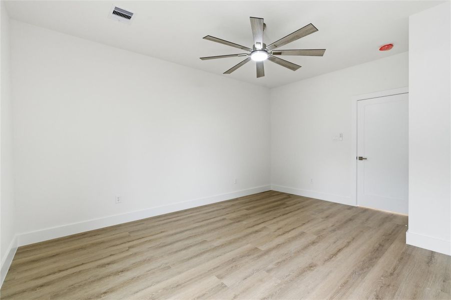 A spacious third-floor secondary bedroom offers clean finishes and a versatile layout for guests or a home office.
