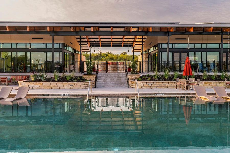 Modern architecture frame a sparkling pool area flanked by stone retaining walls and native landscaping.