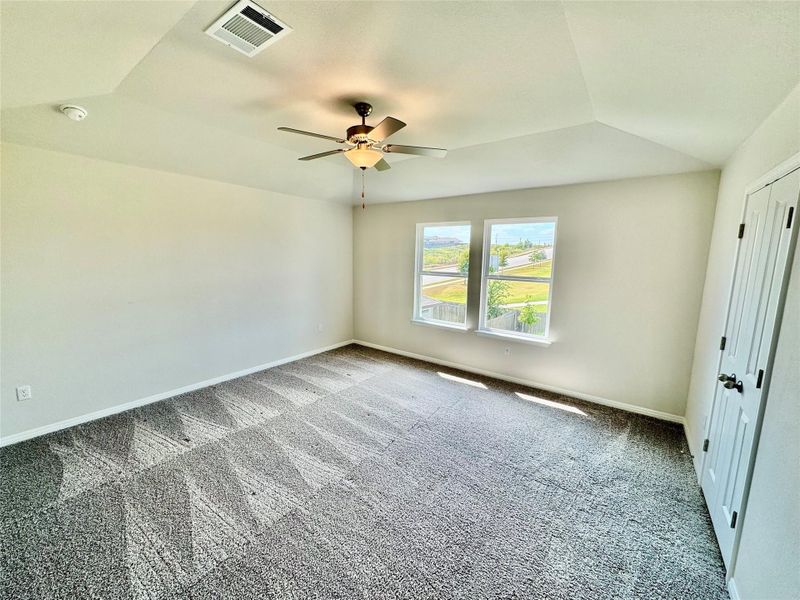 Unfurnished room featuring carpet floors, vaulted ceiling, and a ceiling fan