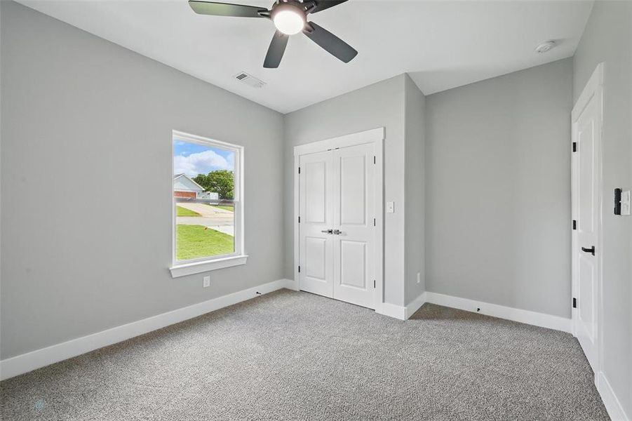 Unfurnished bedroom featuring carpet, baseboards, a closet, and ceiling fan