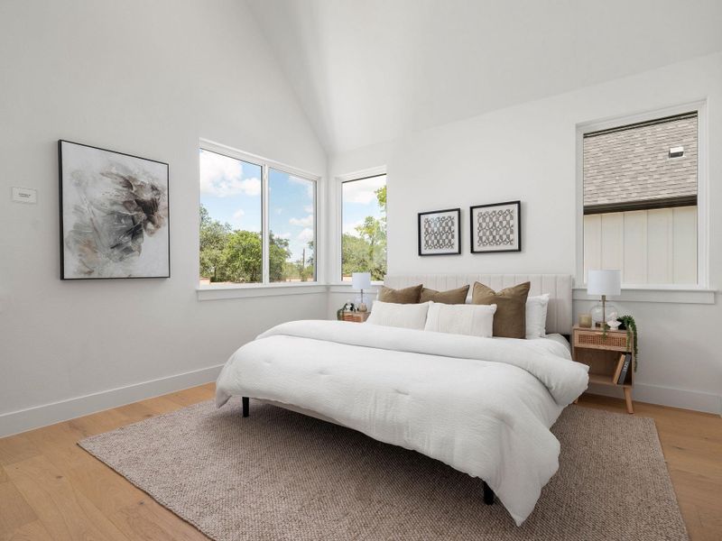 Cathedral ceilings enhance this naturally illuminated bedroom with a tranquil, airy feel.