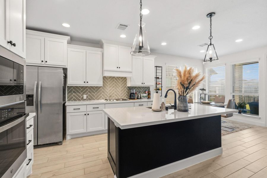 Beautiful kitchen with a large island, abundant cabinetry, and stainless-steel appliances.