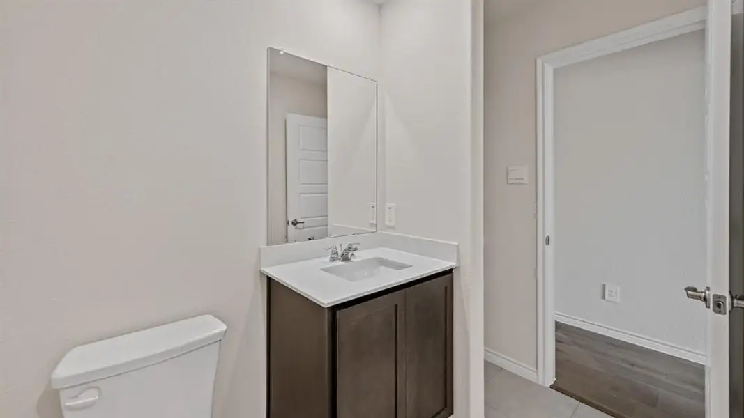 Bathroom vanity with a white countertop and dark wood cabinetry Bathroom vanity with a white countertop and dark wood cabinetry