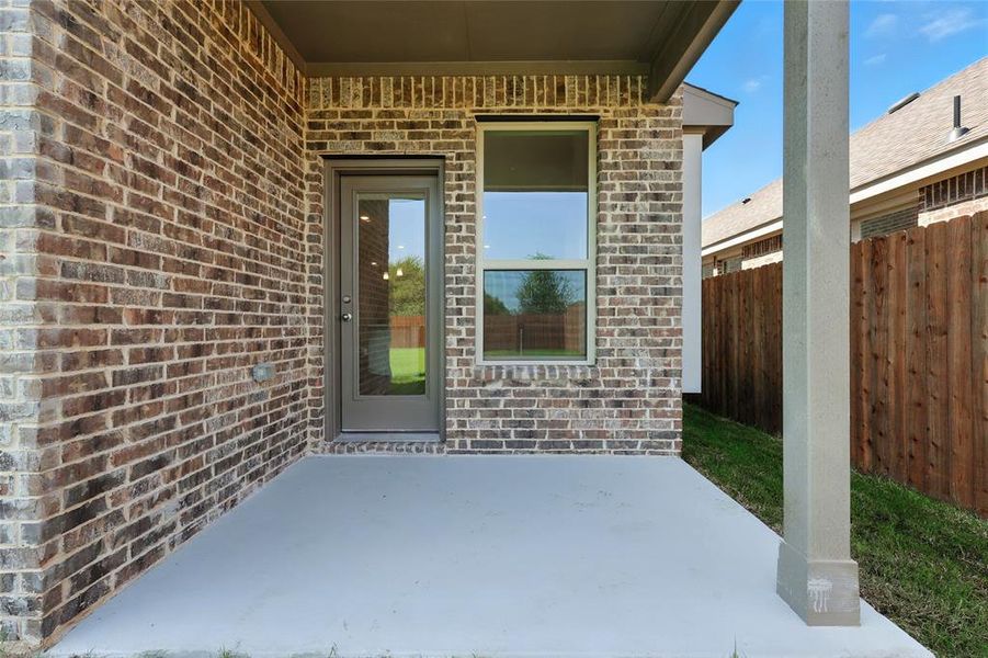 View of exterior entry featuring brick siding and a patio area View of exterior entry featuring brick siding and a patio area