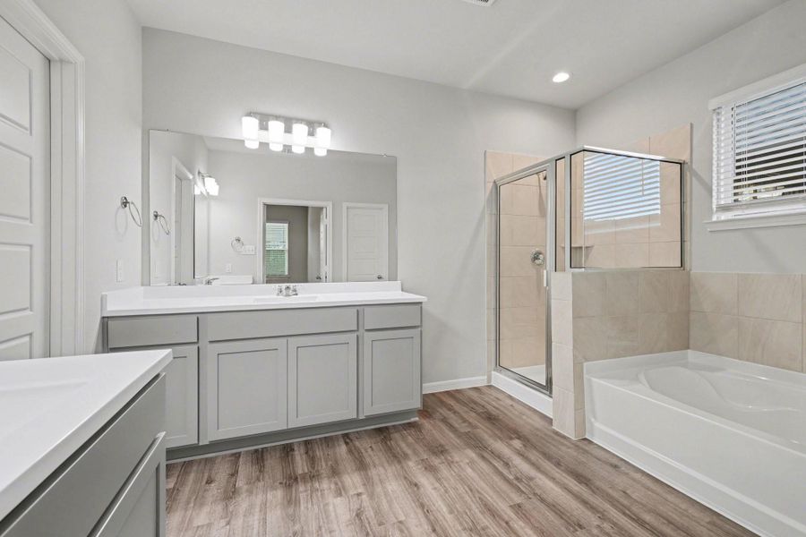 Spacious primary bathroom with dual vanities, large mirrors, and modern lighting. Spacious primary bathroom with dual vanities, large mirrors, and modern lighting.