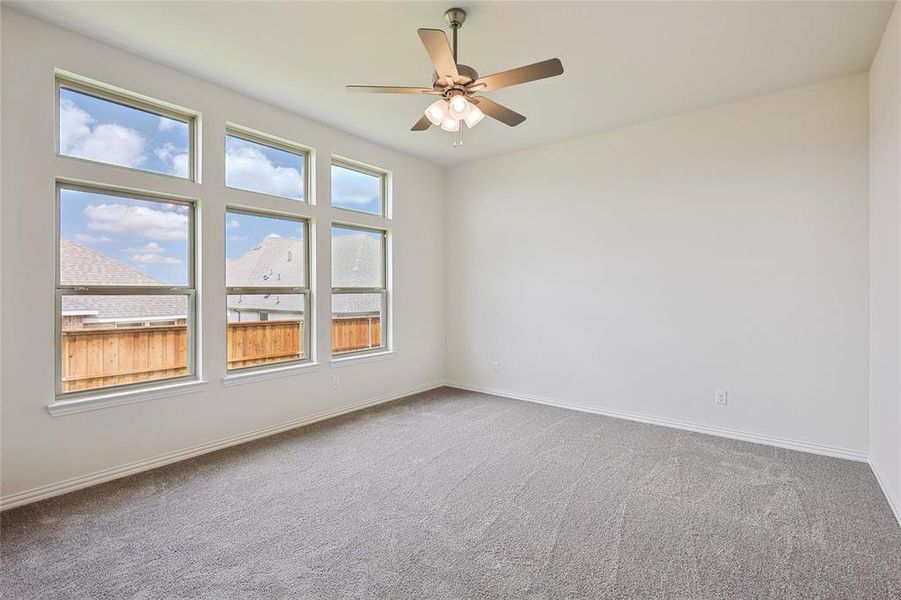 Carpeted spare room with ceiling fan