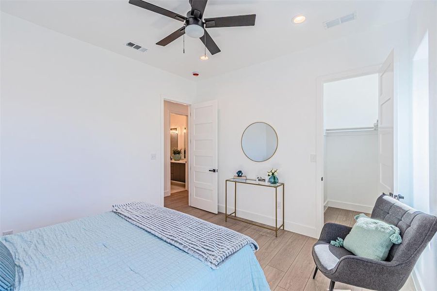 Bedroom featuring light wood finished floors, recessed lighting, a spacious closet, and a ceiling fan Bedroom featuring light wood finished floors, recessed lighting, a spacious closet, and a ceiling fan