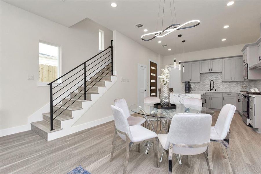 Living Room/Dinning Room with wrought iron staircase design.