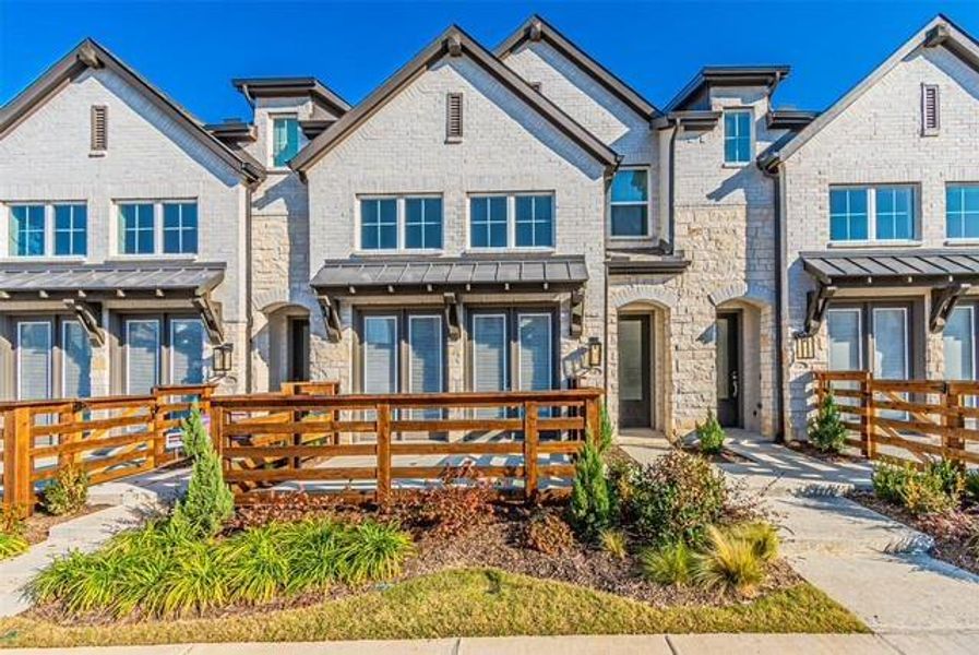 View of front of property with a standing seam roof, brick siding, and a metal roof