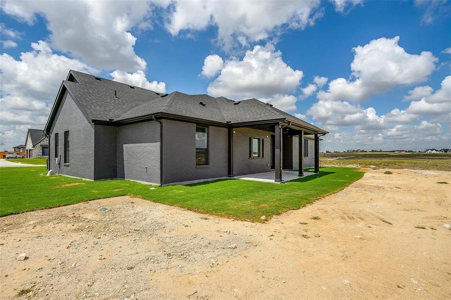 Rear view of property featuring a yard and a patio