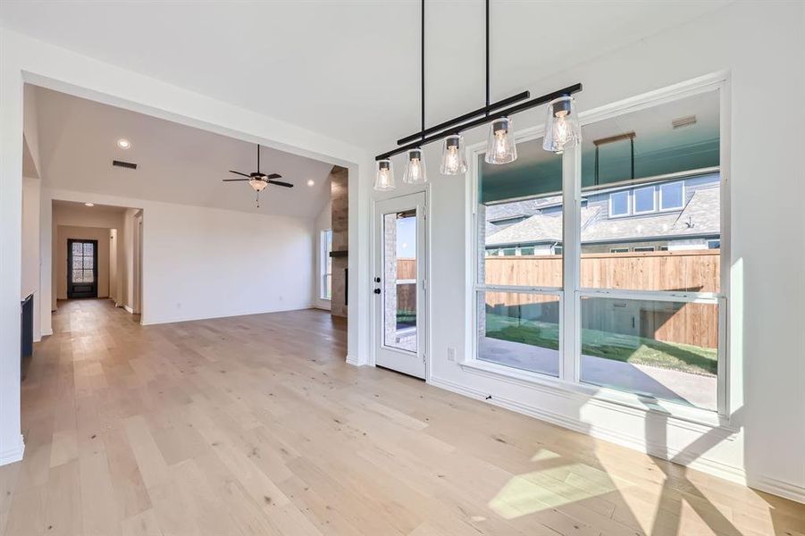 Unfurnished dining area with ceiling fan, a wealth of natural light, and light wood-type flooring