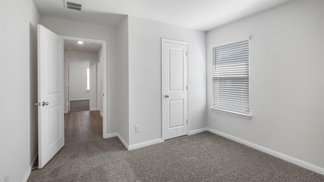 Unfurnished bedroom featuring dark colored carpet and a closet