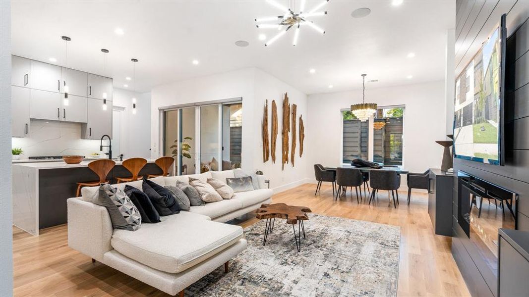 Living room featuring sink, light hardwood / wood-style floors, and an inviting chandelier