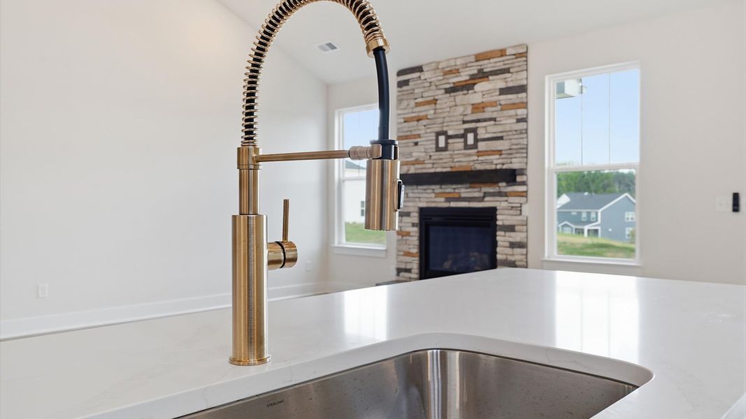 Top-notch kitchen featuring quartz countertops, open sightlines, and bronze hardware by the reputable DRB Homes Top-notch kitchen featuring quartz countertops, open sightlines, and bronze hardware by the reputable DRB Homes