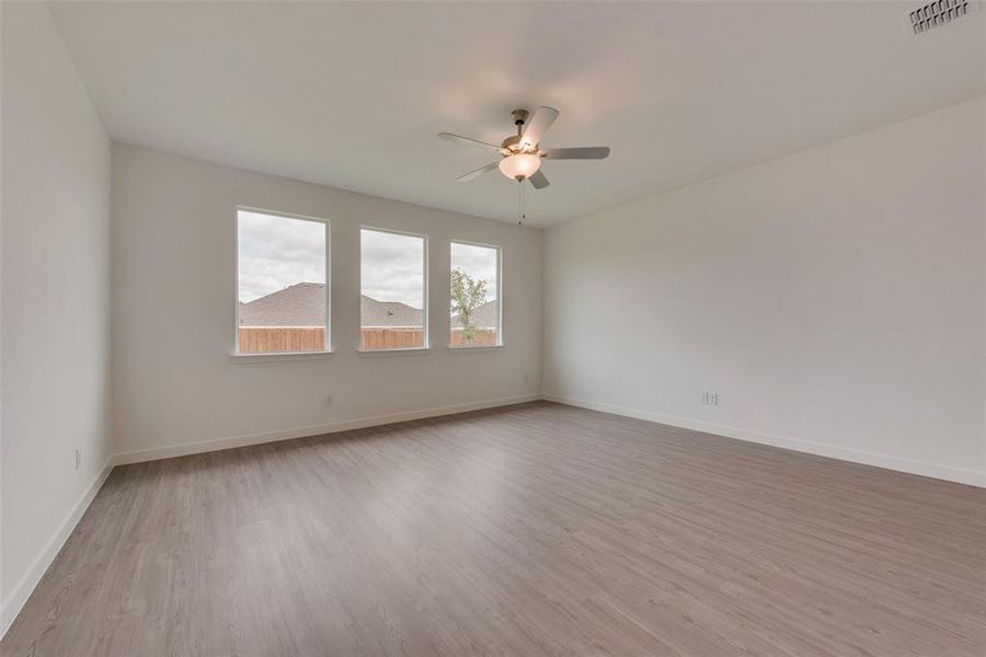 Empty room with ceiling fan and light hardwood / wood-style flooring