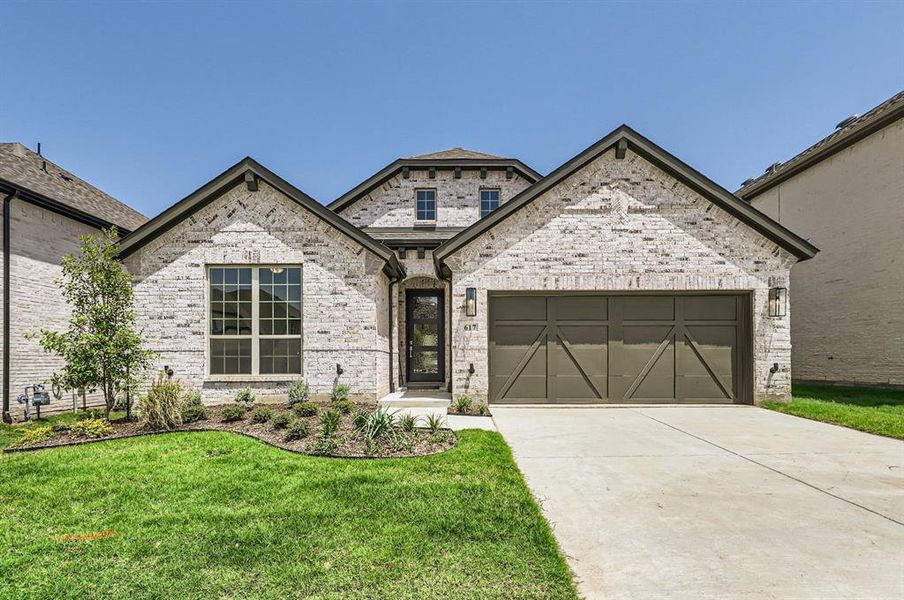 View of front of house with a garage and a front lawn