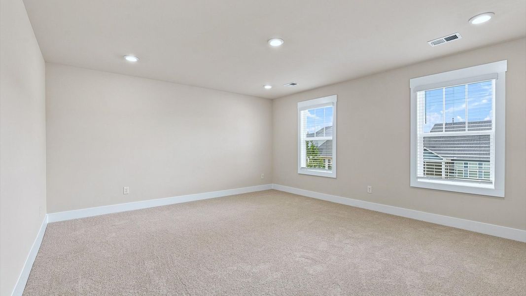 Serene and stylish primary bedroom featuring hardwood flooring and a thoughtful, modern layout