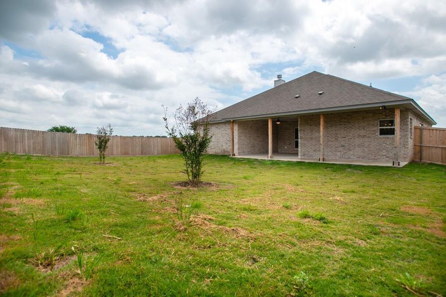 Back of property with a patio, brick siding, and a shingled roof Back of property with a patio, brick siding, and a shingled roof